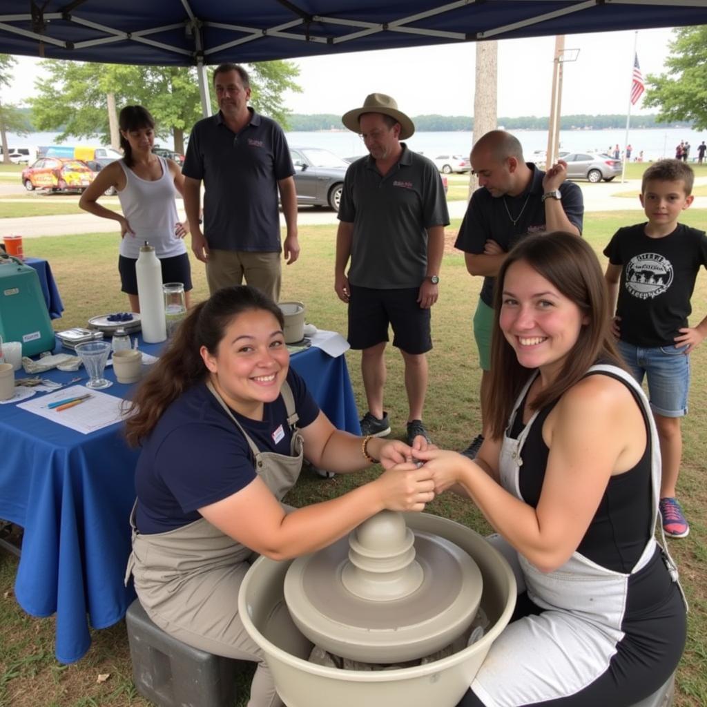 An artist interacts with visitors while demonstrating pottery techniques at their festival booth.