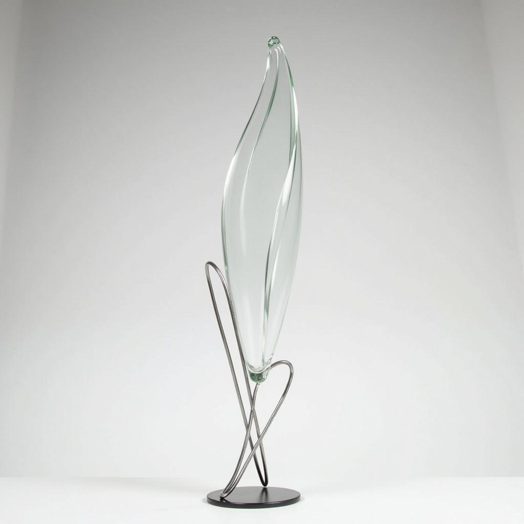 Delicate glass sculpture displayed on a sleek metal stand