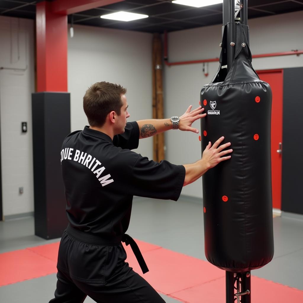 A martial artist practicing strikes on a freestanding martial art dummy