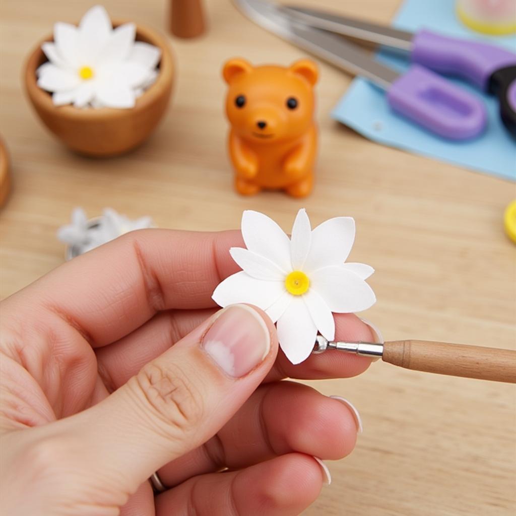 Close-up of a bearly art glue holder being used to apply glue to a delicate paper flower