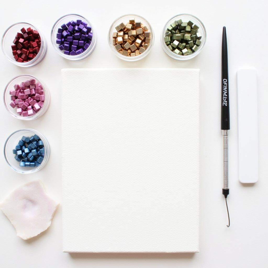 Arrangement of diamond art tools and materials including a canvas, square beads, applicator pen, wax, and tray.