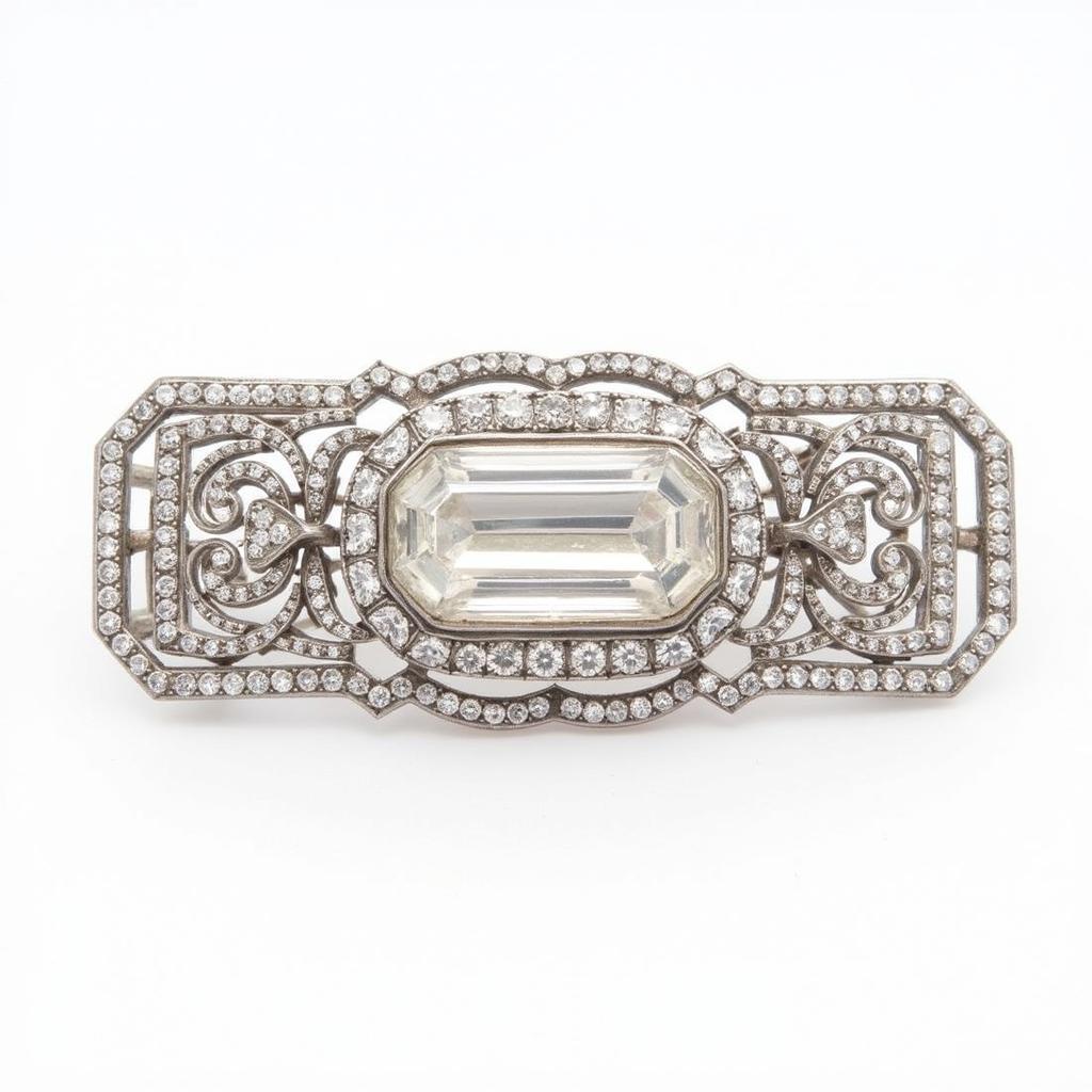 A stunning vintage art deco brooch featuring a large emerald-cut diamond set in platinum, with intricate filigree work surrounding the center stone.