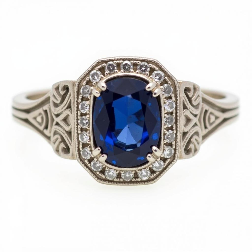 Vintage art deco sapphire and diamond ring with milgrain detailing and a geometric halo.