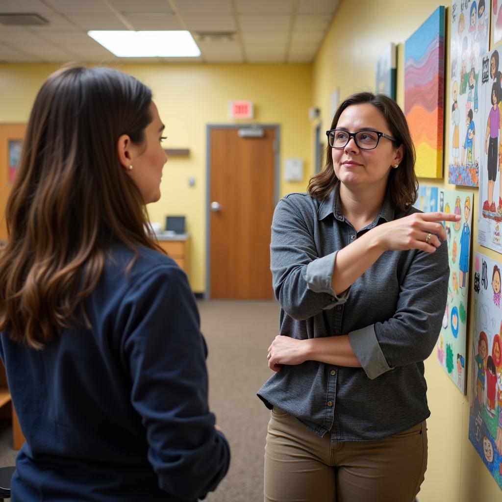 A parent and teacher discussing the curriculum and learning environment of an art class