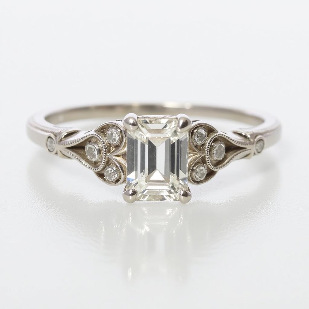 Vintage Art Deco engagement ring featuring an emerald-cut diamond and intricate filigree work.