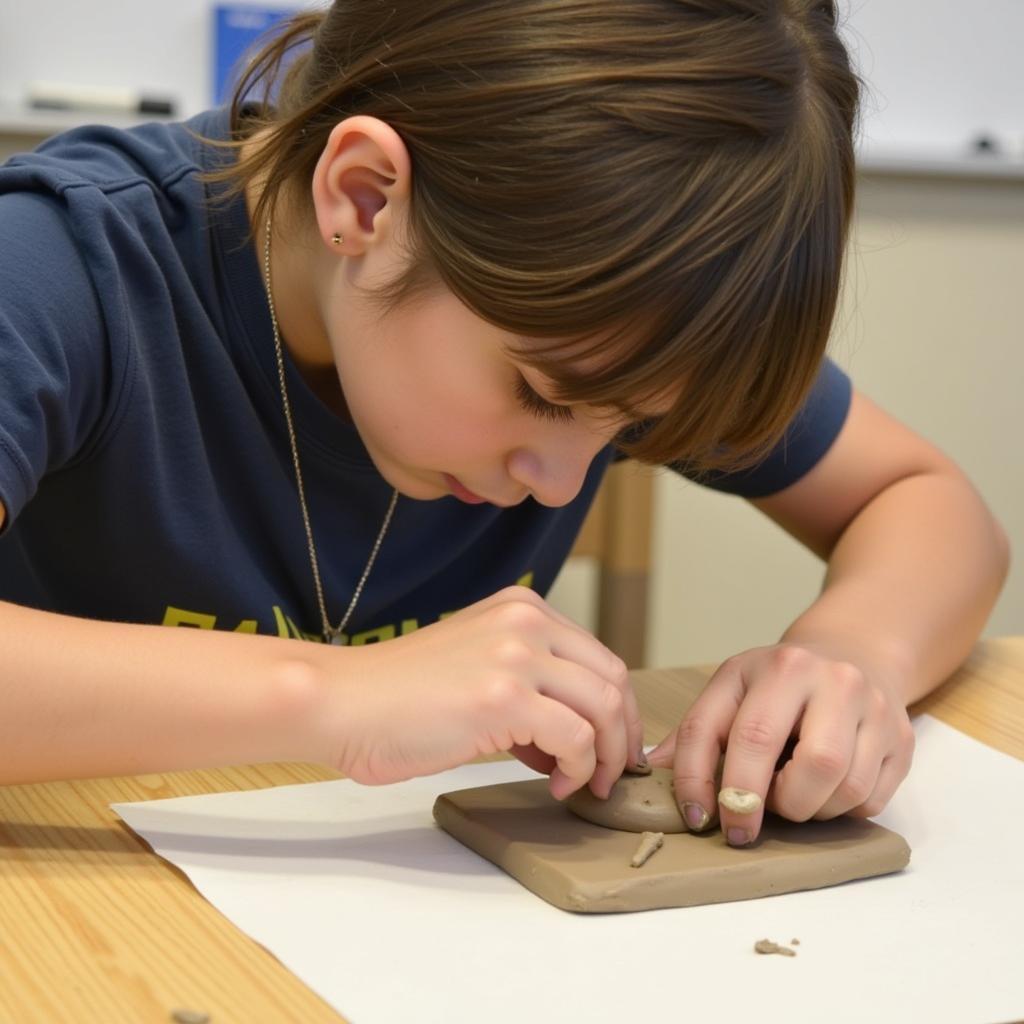 AICE Art student working on a clay sculpture