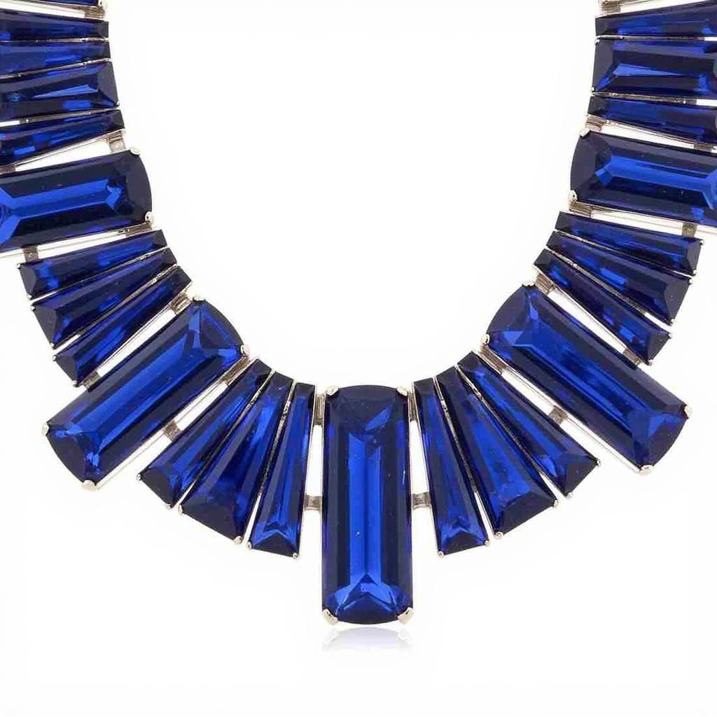 Art Deco sapphire necklace with a platinum setting, featuring a symmetrical design and baguette-cut sapphires.