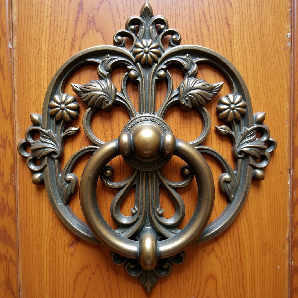 A close-up of a brass art nouveau door knocker with intricate floral designs